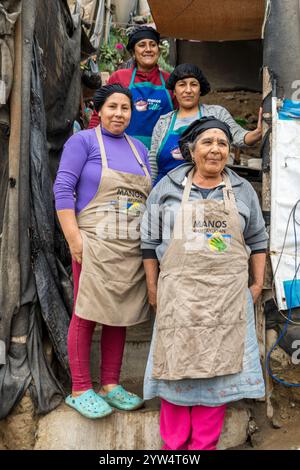 Lurin, Perù - 29 luglio 2023: Donne e uomini che lavorano in una cucina comunitaria posano sul set di scale anteriori Foto Stock