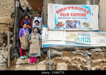 Lurin, Perù - 29 luglio 2023: Donne e uomini che lavorano in una cucina comunitaria posano sul set di scale anteriori Foto Stock