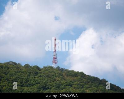 Array di antenne direzionali su una torre di comunicazione rossa e bianca contro il cielo. Foto Stock