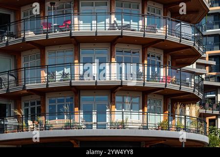 Balcone rotondo con finestre a bovindo della casa o complesso di appartamenti in città. Un moderno edificio residenziale con balconi arrotondati. Contemp Foto Stock