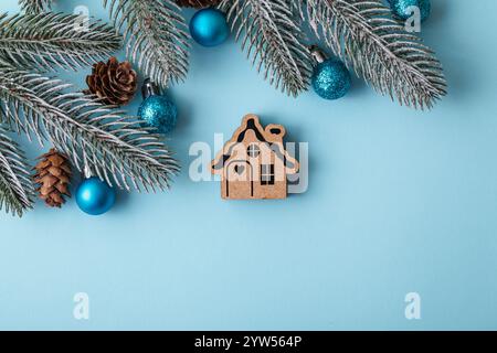 Casa dei giocattoli di legno di Natale su sfondo natalizio blu. Concetto di stare a casa. Copia spazio Foto Stock