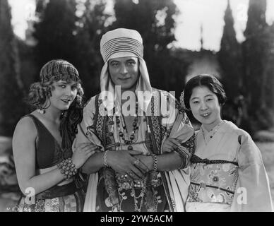 L'attrice giapponese YAEKO MIZUTANI in visita a RODOLPH VALENTINO e VILMA BANKY sul set del FIGLIO DELLO SCEICCO 1926, regista GEORGE FITZMAURICE, romanzo EDITH MAUDE, adattamento dello schermo dello SCAFO FRANCES MARION Settings WILLIAM CAMERON MENZIES United Artists Foto Stock