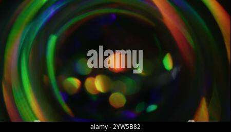 Luce bokeh. Sfondo sfocato. Perdita sfocata raggi verdi gialli sfarfallio dell'arcobaleno la lente del fascio flash si illumina in nero scuro astratto. Foto Stock