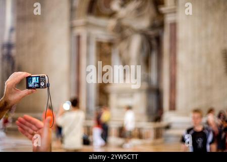 Roma, Italia, 22 luglio 2017, Un visitatore scatta foto all'interno della grande Basilica di San Pietro nella città del Vaticano, circondato da altri turisti che esplorano la città Foto Stock