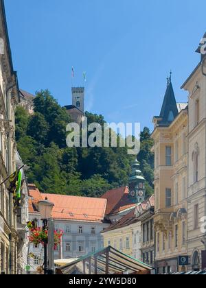 Lubiana, Slovenia - 28 giugno 2024: Castello e la sua torre sul verde fogliame dalla via Stritarjeva ulica Foto Stock