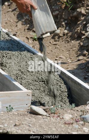 Calcestruzzo bagnato miscela viene versata in forme e su rebar per creare le fondamenta per una casa. Foto Stock