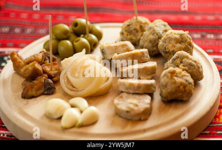 tradizionale altopiano natalizio con vari antipasti di maiale su tradizionale stoffa rossa Foto Stock