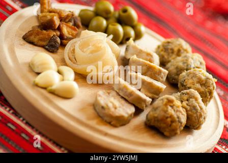 tradizionale altopiano natalizio con vari antipasti di maiale su tradizionale stoffa rossa Foto Stock