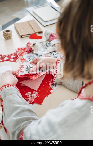 Tessuto a tema natalizio con motivi a fiocco di neve. Promozione di confezioni regalo sostenibili, celebrazioni ecologiche e materiali riutilizzabili a zero sprechi Foto Stock