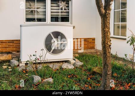 Nuova pompa di calore dell'aria installata di fronte alla casa di famiglia, concetto di energia rinnovabile verde Foto Stock