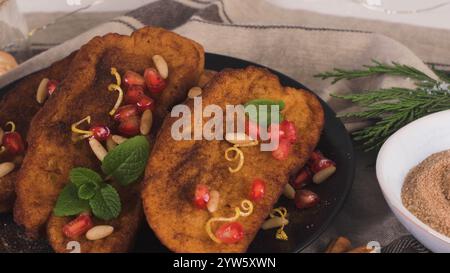 Rabanadas di Natale tradizionale con semi di pommegranate, pinoli e cannella. Torrijas spagnolo o toast francesi vicino sul banco. Foto Stock