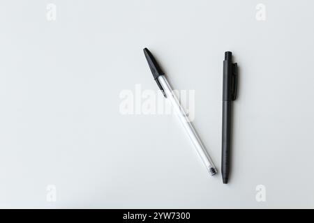 Due penne a sfera in bianco e nero con spazio per la copia. Materiale per ufficio, cancelleria scolastica, concetto di attività di scrittura dell'autore. Semplice e minimalista Foto Stock