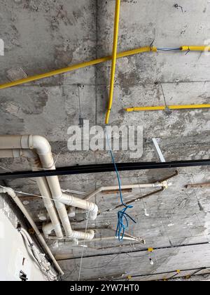 Installazione a soffitto con tubi e conduttori nel cantiere edile Foto Stock