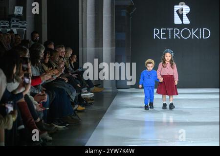 Toronto, ON, Canada - 7 dicembre 2024: Una modella cammina sulla passerella della collezione retro Kid durante la sfilata di moda Toronto Kids Fashion Week. Foto Stock