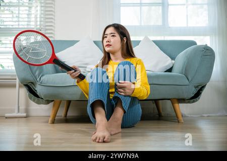 Pavimento asiatico femminile con dispositivo di scambio di zanzare o racchetta di rete elettrica Foto Stock