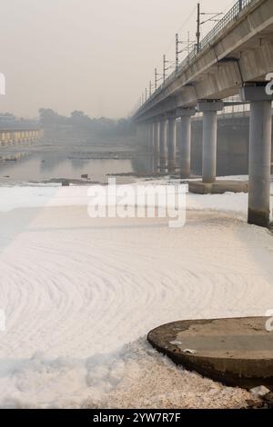 fiume inquinato con effluenti industriali e domestici schiuma tossica e ponte stradale al mattino l'immagine viene scattata presso lo sbarramento del fiume yamuna di okhla delhi india. Foto Stock