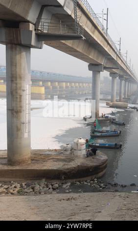 Il Modern Road Bridge che attraversa il fiume contaminato con schiuma tossica e barca dei lavoratori al mattino nebbioso il video viene girato presso il fiume yamuna, sbarramento di okhla delhi in Foto Stock