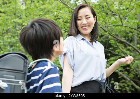 Madre sorridente che parla con il suo figlio delle scuole primarie Foto Stock