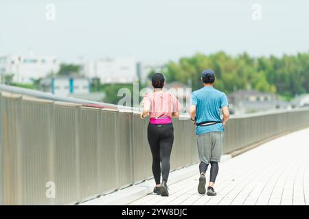 Uomo e donna che fanno jogging per strada Foto Stock