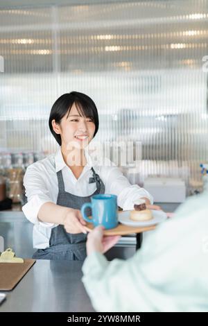 Personale Café Female che consegna i prodotti Foto Stock