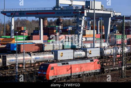 Lipsia, Germania. 26 novembre 2024. Una gru a cavalletto carica un treno merci al terminal container di Lipsia. Il terminal vicino all'aeroporto di Lipsia/Halle e l'adiacente centro merci è considerato un importante hub per la regione economica di Halle/Lipsia. Il DUSS Terminal Leipzig-Wahren è un importante centro di trasbordo per il trasporto combinato in Sassonia. Si trova nel Leipzig Freight Village (GVZ), il più grande parco industriale e di distribuzione dello stato federale. Crediti: Hendrik Schmidt/dpa/Alamy Live News Foto Stock