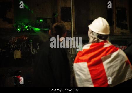 Tbilisi, Georgia - 1 dicembre 2024: I giovani georgiani stanno con le bandiere UE e georgiane del parlamento. Il raduno su Rustaveli Avenue, lo slogan della Foto Stock