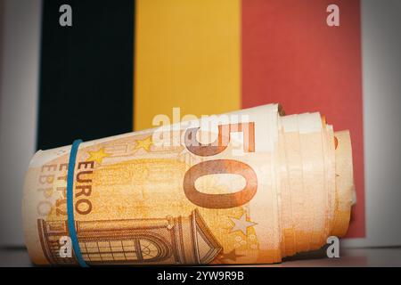 Macro, primo piano delle banconote in euro con bandiera belga come sfondo. Foto Stock