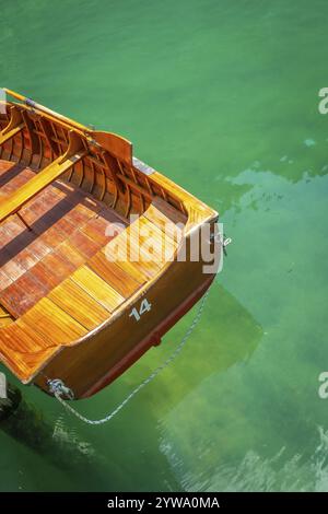 Classica barca a remi in legno che galleggia dolcemente sulle acque cristalline color smeraldo del lago di braies, una destinazione pittoresca nelle dolomiti Foto Stock