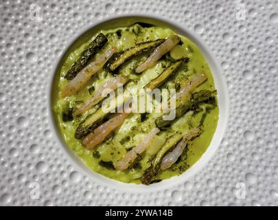 Risotto con asparagi su un bellissimo piatto di design bianco in Italia. Foto Stock