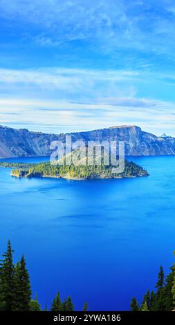 Mattinata al Crater Lake National Park in Oregon, che mette in evidenza le serene acque blu, la foresta sempreverde e l'isola iconica, creare un an tranquillo Foto Stock