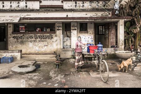 Uomo con risciò che prende acqua, Dacca, Bangladesh, Asia Foto Stock