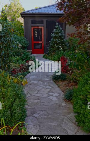Passerella in pietra che conduce attraverso il giardino alla porta Foto Stock