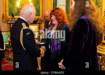 Re Carlo III presenta un emblema di Elisabetta a Rebecca Lombard-Earl, per Vigili del fuoco Fleur Lombard di Avon Fire and Rescue durante la cerimonia inaugurale di presentazione al Castello di Windsor, Berkshire. Il re sta presentando il primo degli emblemi di Elisabetta ai parenti più prossimi di ex vigili del fuoco, agenti di polizia e altri funzionari pubblici che morirono nell'adempimento del dovere. Data foto: Martedì 10 dicembre 2024. Foto Stock