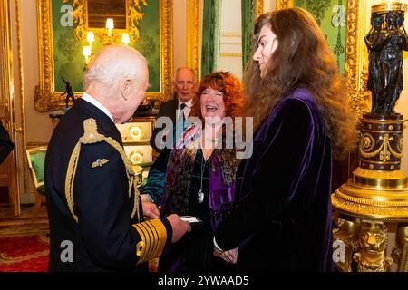 Re Carlo III presenta un emblema di Elisabetta a Rebecca Lombard-Earl, per Vigili del fuoco Fleur Lombard di Avon Fire and Rescue durante la cerimonia inaugurale di presentazione al Castello di Windsor, Berkshire. Il re sta presentando il primo degli emblemi di Elisabetta ai parenti più prossimi di ex vigili del fuoco, agenti di polizia e altri funzionari pubblici che morirono nell'adempimento del dovere. Data foto: Martedì 10 dicembre 2024. Foto Stock