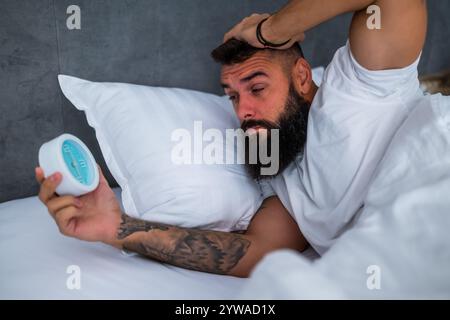 L'uomo si sta svegliando la mattina e tiene il tempo. Foto Stock