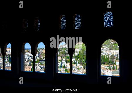 Granada, Spagna - 20 settembre 2024: Paesaggio urbano incorniciato da finestre in stile islamico del Palazzo dell'Alhambra. Foto Stock