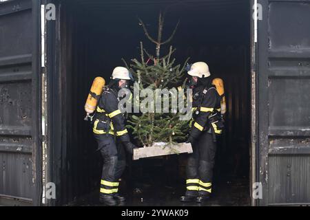 AM Dienstagnachmittag führte die Feuerwehr Hamburg eindrucksvoll vor Augen, wie schnell ein brennender Weihnachtsbaum oder ein Adventsgesteck zur Gefahr werden kann. Dabei Beamte des Trainingszentrums und Lehrgangsteilnehmer ein Wohnzimmer in einen Überseecontainer. Schon kurze Zeit, nach dem Anzünden des Baumes standen bereits Die Coach und der Wohnzimmertisch in Flammen. Dichter schwarzer Brandrauch drang aus dem fiktiven Wohnraum. DAS Löschen mit einem Eimer Wasser oder haushaltsüblichen Kleinlöschern zu diesem Zeitpunkt bereits unmöglich, wie der test simulierte. In der Entstehung des Feue Foto Stock