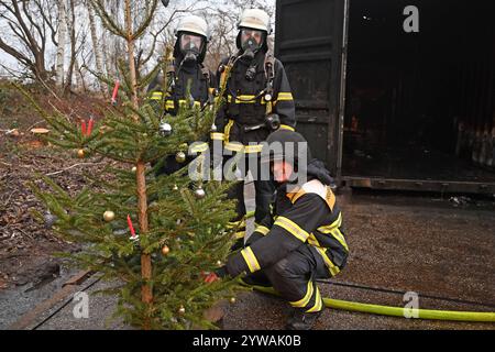 AM Dienstagnachmittag führte die Feuerwehr Hamburg eindrucksvoll vor Augen, wie schnell ein brennender Weihnachtsbaum oder ein Adventsgesteck zur Gefahr werden kann. Dabei Beamte des Trainingszentrums und Lehrgangsteilnehmer ein Wohnzimmer in einen Überseecontainer. Schon kurze Zeit, nach dem Anzünden des Baumes standen bereits Die Coach und der Wohnzimmertisch in Flammen. Dichter schwarzer Brandrauch drang aus dem fiktiven Wohnraum. DAS Löschen mit einem Eimer Wasser oder haushaltsüblichen Kleinlöschern zu diesem Zeitpunkt bereits unmöglich, wie der test simulierte. In der Entstehung des Feue Foto Stock