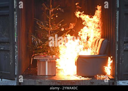 AM Dienstagnachmittag führte die Feuerwehr Hamburg eindrucksvoll vor Augen, wie schnell ein brennender Weihnachtsbaum oder ein Adventsgesteck zur Gefahr werden kann. Dabei Beamte des Trainingszentrums und Lehrgangsteilnehmer ein Wohnzimmer in einen Überseecontainer. Schon kurze Zeit, nach dem Anzünden des Baumes standen bereits Die Coach und der Wohnzimmertisch in Flammen. Dichter schwarzer Brandrauch drang aus dem fiktiven Wohnraum. DAS Löschen mit einem Eimer Wasser oder haushaltsüblichen Kleinlöschern zu diesem Zeitpunkt bereits unmöglich, wie der test simulierte. In der Entstehung des Feue Foto Stock