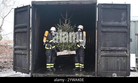 AM Dienstagnachmittag führte die Feuerwehr Hamburg eindrucksvoll vor Augen, wie schnell ein brennender Weihnachtsbaum oder ein Adventsgesteck zur Gefahr werden kann. Dabei Beamte des Trainingszentrums und Lehrgangsteilnehmer ein Wohnzimmer in einen Überseecontainer. Schon kurze Zeit, nach dem Anzünden des Baumes standen bereits Die Coach und der Wohnzimmertisch in Flammen. Dichter schwarzer Brandrauch drang aus dem fiktiven Wohnraum. DAS Löschen mit einem Eimer Wasser oder haushaltsüblichen Kleinlöschern zu diesem Zeitpunkt bereits unmöglich, wie der test simulierte. In der Entstehung des Feue Foto Stock
