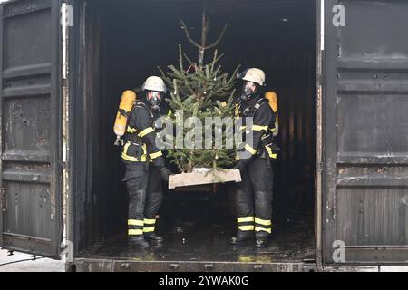 AM Dienstagnachmittag führte die Feuerwehr Hamburg eindrucksvoll vor Augen, wie schnell ein brennender Weihnachtsbaum oder ein Adventsgesteck zur Gefahr werden kann. Dabei Beamte des Trainingszentrums und Lehrgangsteilnehmer ein Wohnzimmer in einen Überseecontainer. Schon kurze Zeit, nach dem Anzünden des Baumes standen bereits Die Coach und der Wohnzimmertisch in Flammen. Dichter schwarzer Brandrauch drang aus dem fiktiven Wohnraum. DAS Löschen mit einem Eimer Wasser oder haushaltsüblichen Kleinlöschern zu diesem Zeitpunkt bereits unmöglich, wie der test simulierte. In der Entstehung des Feue Foto Stock