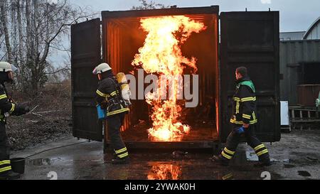 AM Dienstagnachmittag führte die Feuerwehr Hamburg eindrucksvoll vor Augen, wie schnell ein brennender Weihnachtsbaum oder ein Adventsgesteck zur Gefahr werden kann. Dabei Beamte des Trainingszentrums und Lehrgangsteilnehmer ein Wohnzimmer in einen Überseecontainer. Schon kurze Zeit, nach dem Anzünden des Baumes standen bereits Die Coach und der Wohnzimmertisch in Flammen. Dichter schwarzer Brandrauch drang aus dem fiktiven Wohnraum. DAS Löschen mit einem Eimer Wasser oder haushaltsüblichen Kleinlöschern zu diesem Zeitpunkt bereits unmöglich, wie der test simulierte. In der Entstehung des Feue Foto Stock
