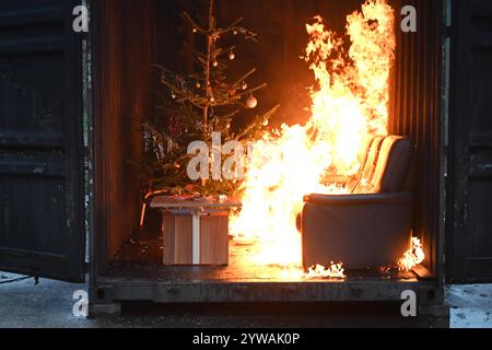 AM Dienstagnachmittag führte die Feuerwehr Hamburg eindrucksvoll vor Augen, wie schnell ein brennender Weihnachtsbaum oder ein Adventsgesteck zur Gefahr werden kann. Dabei Beamte des Trainingszentrums und Lehrgangsteilnehmer ein Wohnzimmer in einen Überseecontainer. Schon kurze Zeit, nach dem Anzünden des Baumes standen bereits Die Coach und der Wohnzimmertisch in Flammen. Dichter schwarzer Brandrauch drang aus dem fiktiven Wohnraum. DAS Löschen mit einem Eimer Wasser oder haushaltsüblichen Kleinlöschern zu diesem Zeitpunkt bereits unmöglich, wie der test simulierte. In der Entstehung des Feue Foto Stock