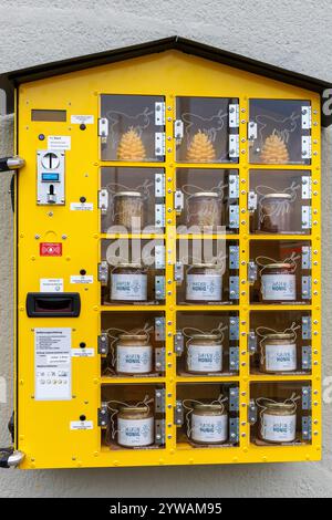 Distributore automatico di miele in una casa nel porto di Deutz, Colonia, Germania. Honigautomat an einem Haus im Deutzer Hafen, Koeln, Deutschland. Foto Stock