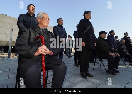 (241210) -- NANJING, 10 dicembre 2024 (Xinhua) -- ai Yiying (1° L), sopravvissuto al massacro di Nanchino, partecipa alla commemorazione familiare per le vittime del massacro di Nanchino a Nanchino, nella provincia di Jiangsu, Cina orientale, 1° dicembre 2024. Per molti anni, è stata una routine annuale per ai Yiying piangere i suoi parenti persi nella sala commemorativa delle vittime nel massacro di Nanchino degli invasori giapponesi. Ai Yiying era una bambina quando la città di Nanchino fu invasa dall'esercito giapponese nel dicembre 1937. Il padre di ai, gli zii e i cugini furono portati via dalla loro casa e uccisi dai soldati giapponesi. Il resto di Foto Stock