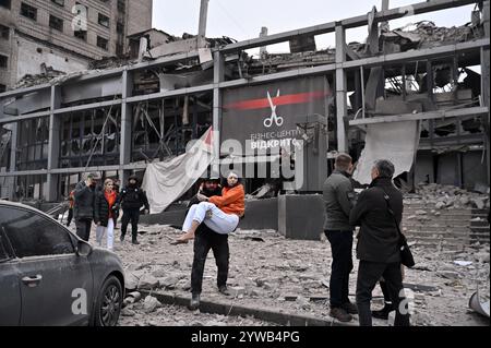 Zaporizhzhia, Ucraina. 10 dicembre 2024. ZAPORIZHZHIA, UCRAINA - 10 DICEMBRE 2024 - Un agente di polizia trasporta una donna salvata da un edificio distrutto da un missile russo, Zaporizhzhia, Ucraina sudorientale. Tre persone sono morte e almeno 14 sono ferite. Un edificio per uffici, un centro medico e altri edifici sono danneggiati. Potrebbero esserci persone sotto le macerie. Crediti: Ukrinform/Alamy Live News Foto Stock