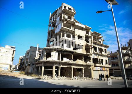 8 dicembre 2024: Homs, Siria. 8 dicembre 2024. Edifici distrutti intorno a Homs visti dopo la caduta della città siriana a causa delle forze dell'opposizione ribelle. Il gruppo islamico di Hayat Tahrir al-Sham, insieme ai gruppi di opposizione siriani alleati, ha dichiarato la cattura di Homs, la terza città più grande della Siria, sabato pomeriggio 7 dicembre. I gruppi ribelli hanno iniziato la loro campagna militare il 27 novembre dal nord della Siria assediando rapidamente territori strategici alle forze governative siriane (Credit Image: © Juma Mohammad/IMAGESLIVE via ZUMA Press Wire) SOLO USO EDITORIALE! Non per USO commerciale! Foto Stock