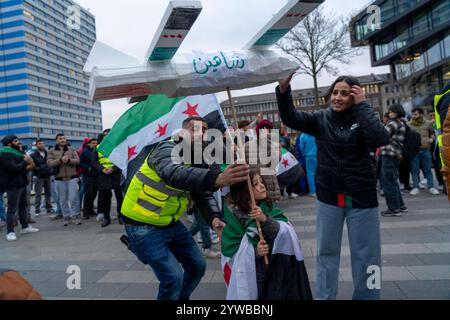 Menschen feiern, bei einer Kundgebung, ausgelassen das Ende des Assad-regimes Assad, nach dem Machtwechsel in Syrien, auf dem Vorplatz des Hauptbahnhofs von Duisburg, NRW, Deutschland, Syrer Freundesfeier **** la gente celebra, in una manifestazione, la fine del regime di Assad, dopo il cambio di potere della corte di Assad, la Germania, gli amici principali della Siria, Duisburg, la Germania, la Germania, la Germania, la Germania, la Germania, la Germania, la Germania Foto Stock