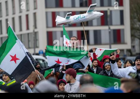 Menschen feiern, bei einer Kundgebung, ausgelassen das Ende des Assad-regimes Assad, nach dem Machtwechsel in Syrien, auf dem Vorplatz des Hauptbahnhofs von Duisburg, NRW, Deutschland, Syrer Freundesfeier **** la gente celebra, in una manifestazione, la fine del regime di Assad, dopo il cambio di potere della corte di Assad, la Germania, gli amici principali della Siria, Duisburg, la Germania, la Germania, la Germania, la Germania, la Germania, la Germania, la Germania Foto Stock