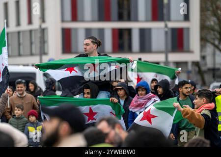 Menschen feiern, bei einer Kundgebung, ausgelassen das Ende des Assad-regimes Assad, nach dem Machtwechsel in Syrien, auf dem Vorplatz des Hauptbahnhofs von Duisburg, NRW, Deutschland, Syrer Freundesfeier **** la gente celebra, in una manifestazione, la fine del regime di Assad, dopo il cambio di potere della corte di Assad, la Germania, gli amici principali della Siria, Duisburg, la Germania, la Germania, la Germania, la Germania, la Germania, la Germania, la Germania Foto Stock